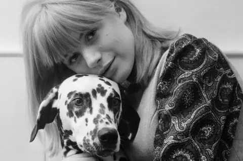 Getty Images Marianne Faithfull as a young woman posing with a dog