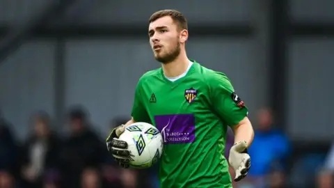 Owen Mason holding the ball while playing for Wexford