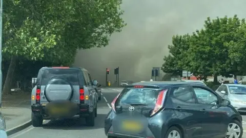 Supplied An image showing stationary cars in the middle of the road as thick plumes of smoke are blown through the streets