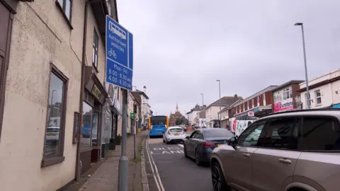 A bus and cars driving along the bus lane in Heavitree, Exeter