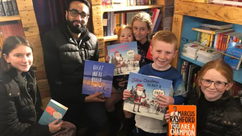 Imran Hafeez of the National Literacy Trust, with children aboard the Bradford Stories Bus, which promotes reading in communities where library provision is low or underused