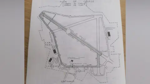 Paul Joslin/BBC A line drawing showing the map of the 1946 Gransden Lodge motor racing circuit. It includes details on the entrance, the car parks and the track itself is highlighted with lines. 