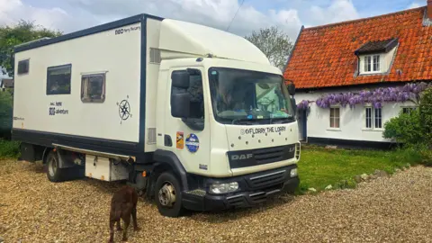 Florry the Lorry A large white lorry parked outside a picture-esque cottage. 