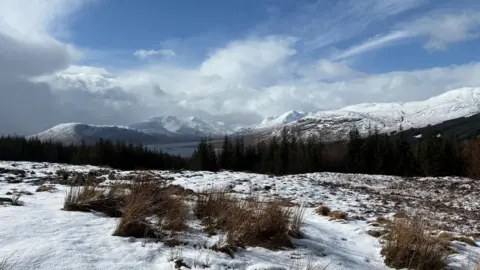 Yesterdaysman/BBC Weather Watchers A view over snow-covered moorland towards snow-covered mountains under a cloudy sky. 