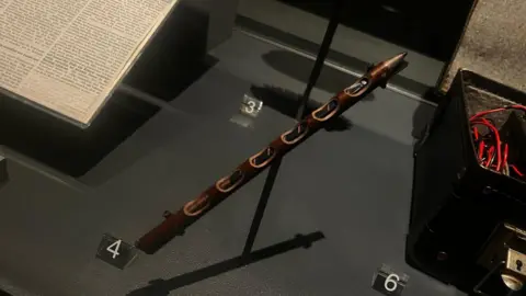 Anna Jameson/BBC A hollowed-out pencil revealing the radio transmitter it concealed. It is on a display stand.