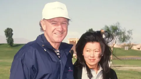 Getty Images Gene Hackman in white cap and blue jacket on golf course with wife Betsy Arakawa at Rancho Mirage in California, 30 November 1991