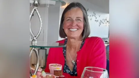 University Hospital Southampton Alison has medium length brown hair and is wearing a bright pink cardigan.