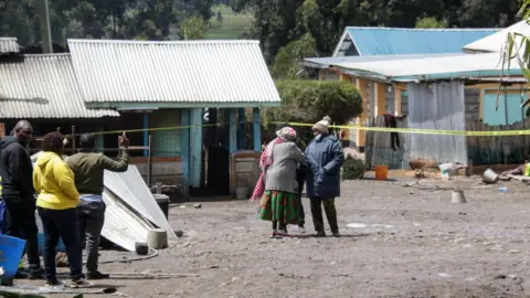 EPA A man speaks to a woman in front of cordoned-off area of the aftermath of the school fire