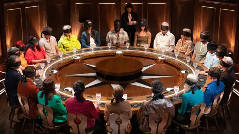 BBC/Studio Lambert/Euan Cherry Contestants sit at the roundtable in the opening episode of The Traitors, season four