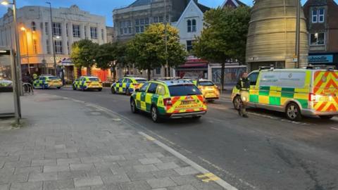 Ambulance and police cars block road 