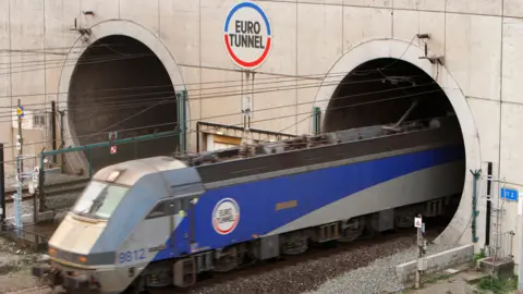 PA Media A train leaving the Eurotunnel at Coquelles in France, in the blue and grey livery of Channel Tunnel company Eurotunnel 