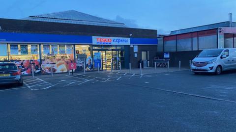 Tesco Express with doors open in the evening 