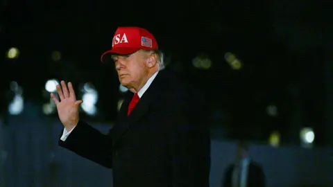 Donald Trump wearing a red MAGA hat