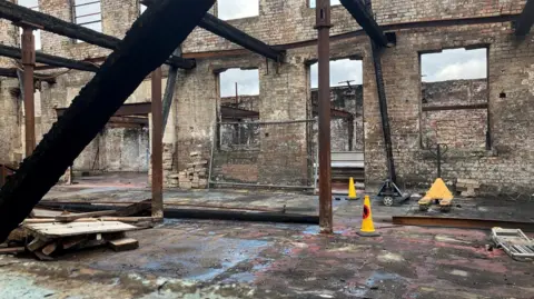 The charred remains of a storage facility on Annison Street in Bradford, with windows and doors removed. 