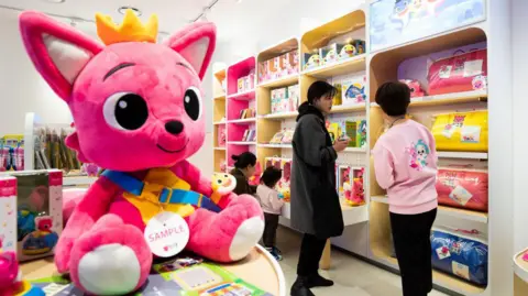 Getty Images Customers browse at toys as a giant doll of the company's Pinkfong fox character is displayed at the firm's store in South Korea