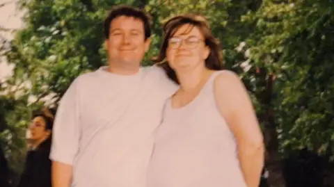 Family handout A husband and wife face the camera on a summer's day, the man has his arm around the woman. The woman is pregnant and wearing a white dress with a black bag held behind her. The man is in jeans with a white T-shirt.