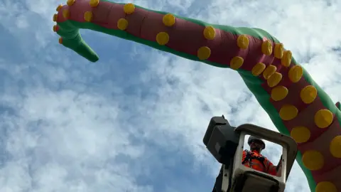  Emma Baugh/BBC Ross Bowden of Peterborough Highway Services putting up an inflatable tentacle on the top of Peterborough Cathedral 
