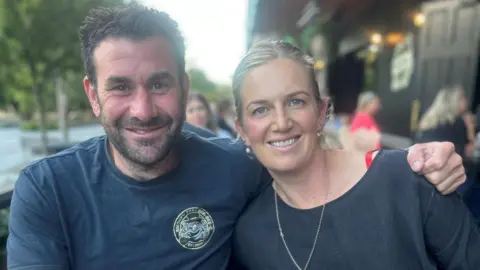 Lori Carnochan A man and a woman sitting at a picnic bench with drinks in front of them