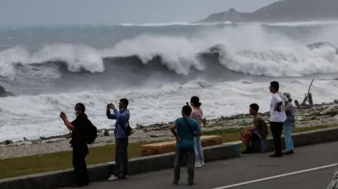Residents observe huge waves brought by Typhoon Bavi in Hualien city, Taiwan