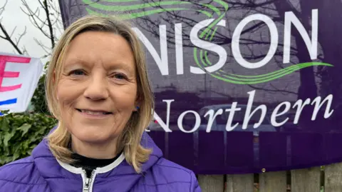 Union worker Clare Williams standing in front of a union flag