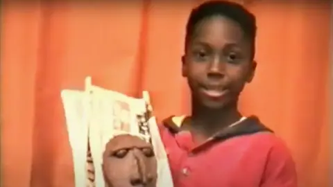 Elijah Turay Elijah Turay, as a boy, holds a clay mask.