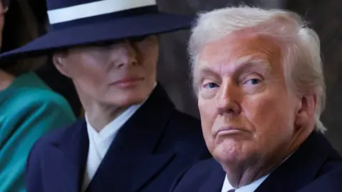 Reuters US President Donald Trump looks down   the lens connected  the inauguration time  of his 2nd  Presidential word  with archetypal  woman  Melania down  him, wearing a ample  navy hat.