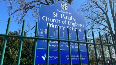 Street view of the school. A blue sign reads: 'St Paul's Church of England Primary School'