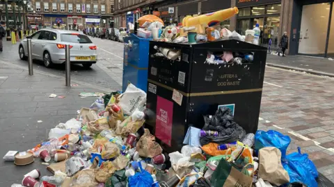 PA Media An overflowing bin in Glasgow