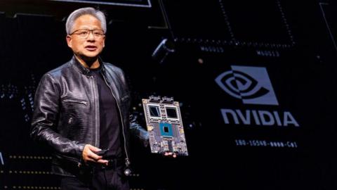 Nvidia's CEO Jensen Huang holds a mock computer chip delivers his keystone speech ahead of Computex 2024 in Taipei on June 2, 2024.