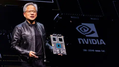 Nvidia's CEO Jensen Huang holds a mock computer chip delivers his keystone speech ahead of Computex 2024 in Taipei on June 2, 2024.