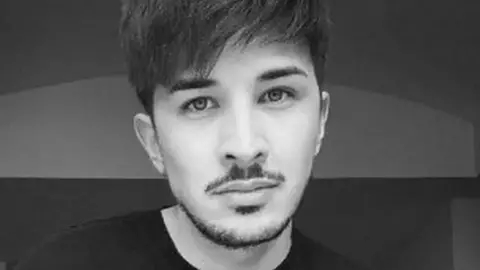 Family handout Black and white image of Martyn Hett with black hair and stubble wearing a black long sleeve top.