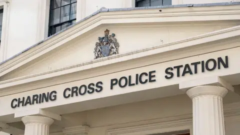 The exterior facade of Charing Cross Police Station, featuring its columned entrance and official signage.