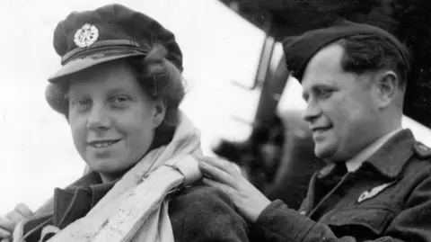 Il pilota di aereo del Ministero della Difesa Edna Birbick viene sottoposto a un'ispezione del paracadute da parte del maresciallo FB Knight di Melbourne, Australia, 13 giugno 1944