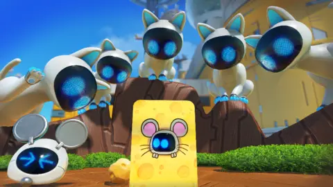 A group of Asobi Five, white, cats with black face masks train their bright blue LED eyes on a board decorated like a piece of cheese with a mouse in the middle. A small robot is looking through the hole in the middle of the board, its blue eyes darting nervously.