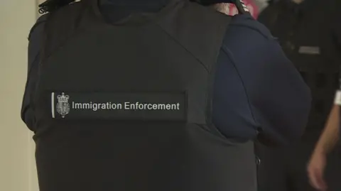 BBC Image of Immigration Enforcement Officer in black jacket