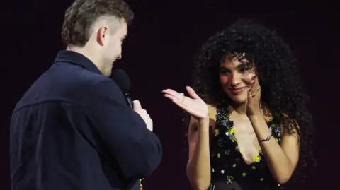 Reuters Olivia Dean applauds collaborator Sam Fender