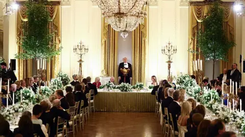 Getty Images US Donald Trump speaks as he hosts Britain's King Charles III and Queen Camilla during a State Dinner in the East Room of the White House in Washington, DC, on April 28, 2026. 