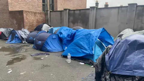 Grainne Ni Aodha/PA Wire Tents are cleared after men who had been camping at the International Protection Office on Mount Street were taken by bus to a site at Crooksling on Saturday morning. Picture date: Saturday March 16, 2024. PA Photo