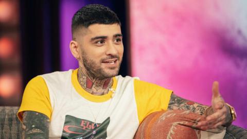 Zayn Malik on the sofa talking to Kelly Clarkson on her chat show in the US