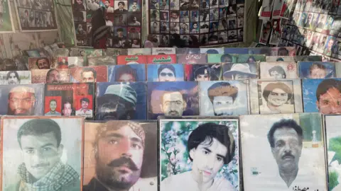 BBC/Farhat Javed Photographs of missing men are displayed at protests - they appeard to be of all ages, in photos lines up n the ground, and posters hanging at the back.