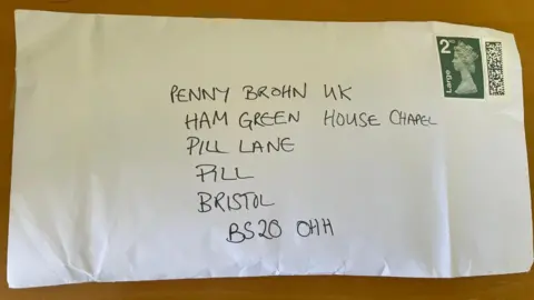 Penny Brohn UK A white, stamped, handwritten envelope with an opening on its right edge 