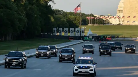 Reuters A fleet of black cars led by a police vehicle drive down the drained bed of the Lincoln Memorial reflecting pool with the base of the Washington Monument and the US Capitol visible in the background