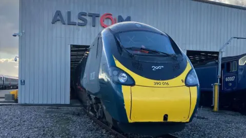 A picture of an Avanti West Coast Pendolino train on the train yard with the Alstom branding above the carriage.