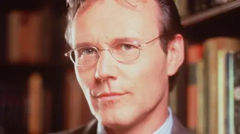 Anthony Head poses for a photo in character as Rupert Giles from Buffy the Vampire Slayer 