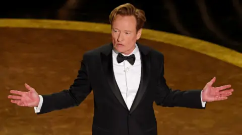 Getty Images Host Conan O'Brien speaks onstage during the 97th Annual Oscars at Dolby Theatre on March 02, 2025 in Hollywood, California. (Photo by Kevin Winter/Getty Images)
