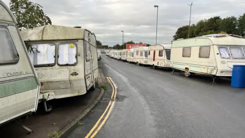 BBC The caravans in Bristol lined up on either side of the road where Home Office officials raided last week