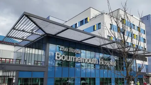 The new front entrance of Bournemouth hospital with a blue glass entrance building. 