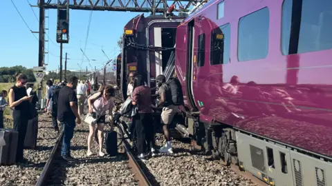Justin Rivett Passengers get off a train that has crashed with another one near Bedford.