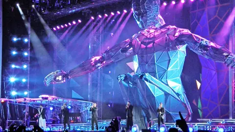 Getty Howard Donald, Robbie Williams, Gary Barlow, Jason Orange and Mark Owen of Take That perform on stage in front of a 60ft giant robot, during the band's 'Progress' tour at Wembley Stadium