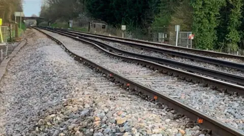 The tracks which have buckled as the embankment has fallen